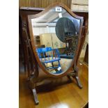 An early 20th Century Georgian style shield shaped dressing table mirror, set on slender swept