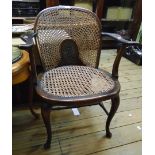 An early 20th Century stained beech framed elbow chair with moulded splat and fan-shaped rattan