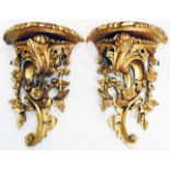 A pair of 14" Rococo style gilt wood wall brackets with semi-circular platform tops and ornate C-