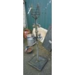 A 4' 2" weathered iron torchere stand with wrought iron scroll to stem and square platform base