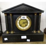A late Victorian black slate cased mantel clock of architectural design with twin flanking columns