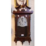 A reproduction stained wood cased Vienna style wall clock with brushed metal printed dial, visible