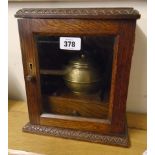 A 9" early 20th Century polished oak smoker's cabinet with brass tobacco pot, pipe racks and