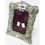 An ornate silver fronted photograph frame with scroll and blind fretwork decoration - Chester 1895