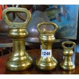 Three graduated brass bell weights, the largest by Avery Ltd.