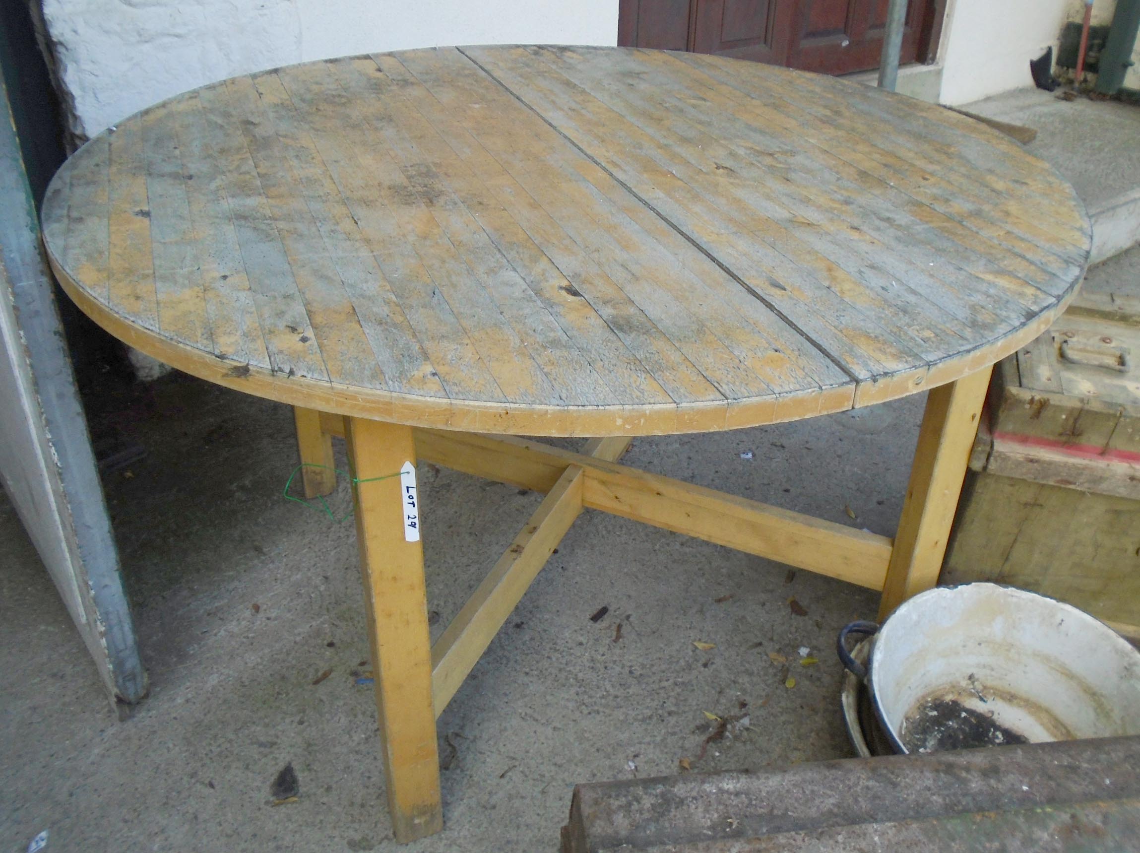 A 4' 4" diameter painted wood extending dining table, set on square supports with X-stretcher