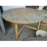 A 4' 4" diameter painted wood extending dining table, set on square supports with X-stretcher