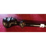 An African ebonised walking stick with carved head finial