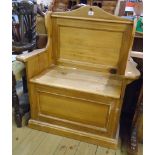 A 33" waxed pine hall bench with shaped panelled back, armrests and locker seat, set on plinth base