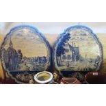 A pair of 22" high Delft wall plaques of shaped design, both decorated with street scenes - 18 1/