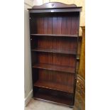 A 34" 20th Century wood grained five shelf open bookcase with moulded pediment and squat bun feet
