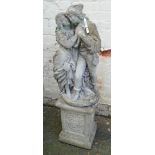 A cast concrete garden statue in the form of a courting couple, set on a decorative pedestal