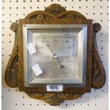 A mid 20th Century ornate carved oak framed British made aneroid wall barometer with chrome plated