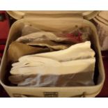 A vintage vanity case containing a collection of kid leather and other gloves