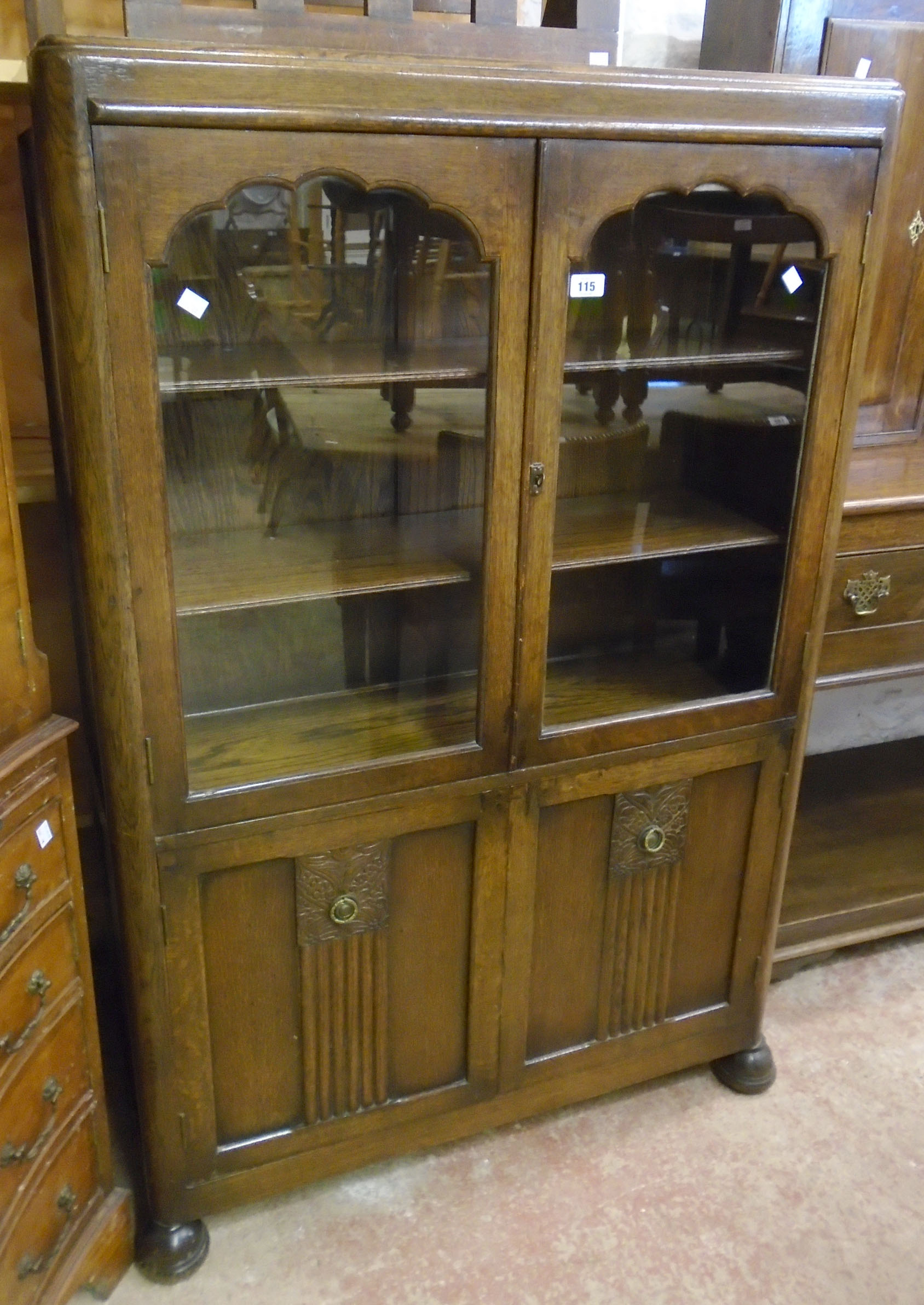 A 36" 1930's polished oak display cabinet with three shelves enclosed by a pair of glazed panel