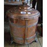 A copper two handled lidded coal bucket with two bands of embossed decoration, set on claw feet