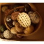 A box containing assorted stone and glass decorative eggs