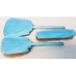 An Art Deco three piece silver and blue enamel backed hand mirror and brush set - Birmingham 1935/