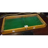A 21 1/2" vintage stained wood tabletop display case with glass lid enclosing a baize lined and