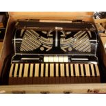 A vintage hard cased Soprani 120 button bass piano accordion in black finish