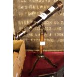 A reproduction brass desk telescope set on a tripod base