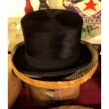 A vintage black top hat by Henry Heath Ltd. in brown leather case