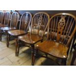 A set of six antiqued stained wood framed wheel back kitchen chairs with solid elm seats and