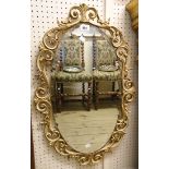 A mid 20th Century Aisonea ornate parcel gilt framed bevelled oval wall mirror