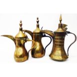 Two Indian graduated brass coffee pots with turned finials and vajra crown marks - sold with an