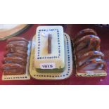 A Watcombe Pottery motto ware cheese dish and two toast racks, motto and scroll - cheese dish