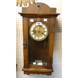 An oak Arts and Crafts style wall clock with incised decoration, studded metal mounts and visible