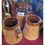 A set of four Moy part glazed terracotta mugs with applied symbols of English heritage comprising