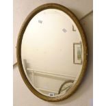 A gilt gesso framed bevelled oval wall mirror