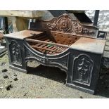 A cast iron fire grate with flanking stove plates