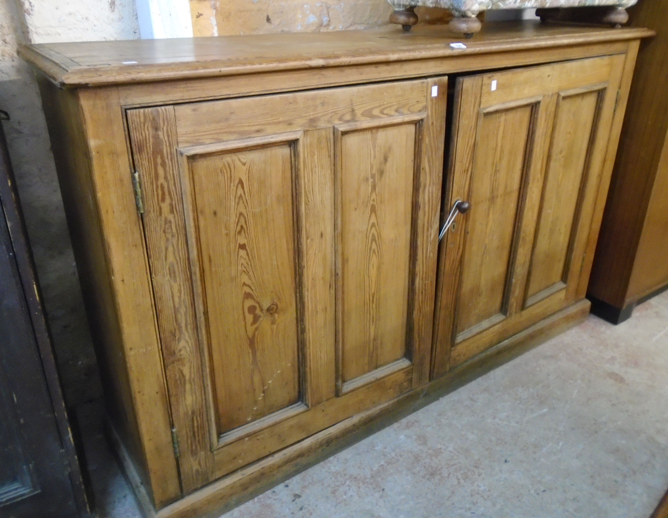 A 5' 10" Victorian pitch pine book cabinet base with shelves enclosed by a pair of panelled doors,