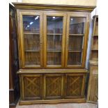 A 4' 10" American antiqued wood two part cabinet with part glazed shelves enclosed by flanking