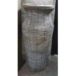 A slender reed and wire tall vase style plant stand