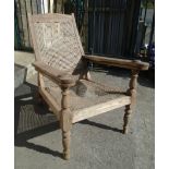 A late 19th Century teak framed plantation chair with extending swivel action leg rests, rattan back