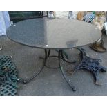 A 4' diameter polished granite topped table, set on splayed painted metal base