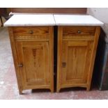 A pair of 15 1/2" varnished pine bedside cabinets with white marble tops, single drawer and panelled