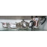A four piece silver plated tea set with composite handles and cast paw feet