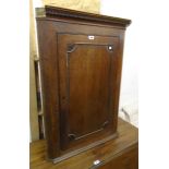 A 28" antique oak wall hanging corner cupboard with moulded cornice and scalloped shelves enclosed