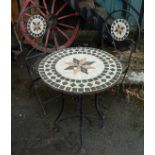 A wrought iron patio table and pair of chairs with mosaic decoration