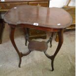 A 27" early 20th Century mahogany two tier occasional table with shaped surfaces and slender