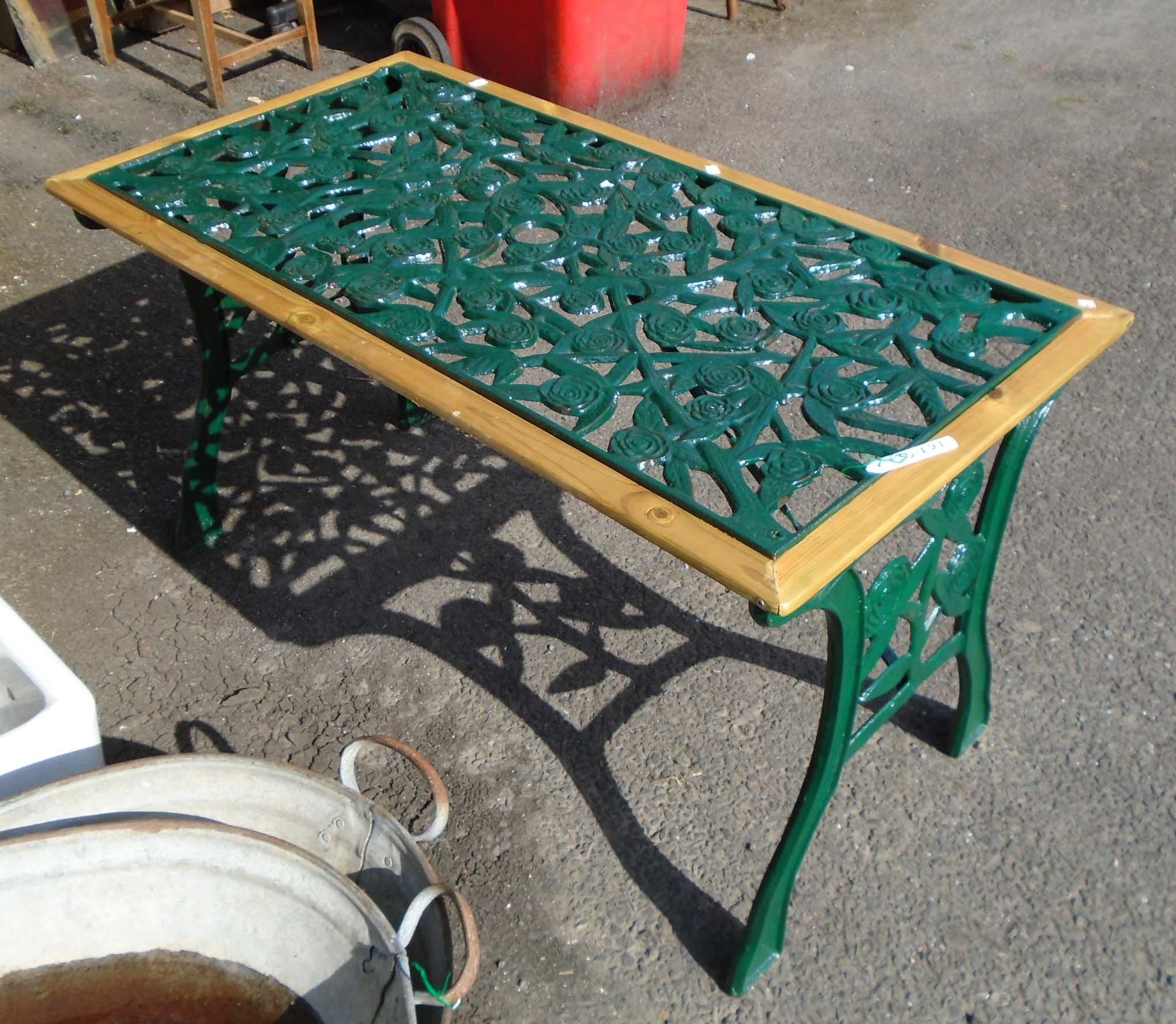 A 3' 10" modern cast iron garden table with rose decoration