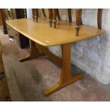 A 5' Ercol light wood dining table set on shaped standard ends - for repolishing