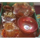 A collection of orange carnival glass including footed bowl, jugs, vase, etc.