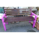A 4' 8" wooden garden bench with bright pink painted finish