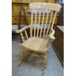 A modern blond wood lath back rocking chair