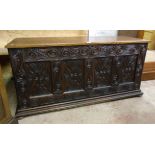 A 4' 5" antique polished oak coffer with decorative carved quadruple panel front and later